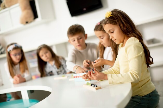 Groep kleine kinderen spelen met voorschoolse houten educatief speelgoed