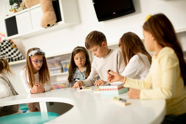 Groep kleine kinderen spelen met voorschoolse houten educatief speelgoed