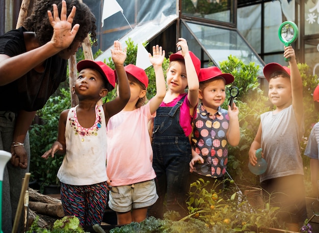 Foto groep kleuterschooljonge geitjes die tuinierend in openlucht leren