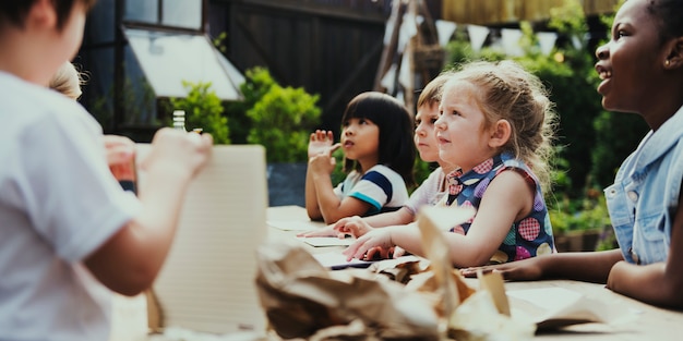 Groep kleuterschooljonge geitjesvrienden die kunstklasse in openlucht trekken