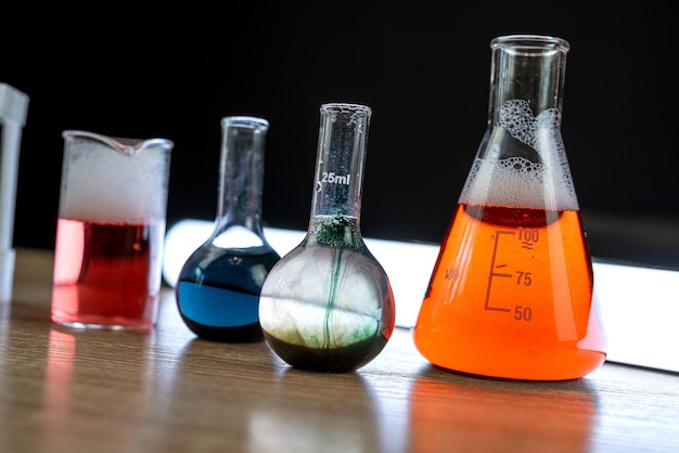Foto groep laboratoriumkolven en beker voor experimenten met kleurvloeistof in een wetenschappelijk laboratorium