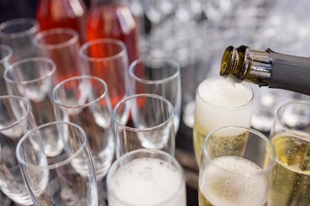 Foto groep lege en transparante champagneglazen in een restaurant. schone glazen op een tafel bereid door de barman voor champagne.