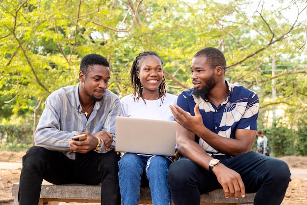 Groep leren millennial Afro-Amerikaanse studenten informatica aan de universiteit of hogeschool met behulp van laptop buiten de schoolcampus