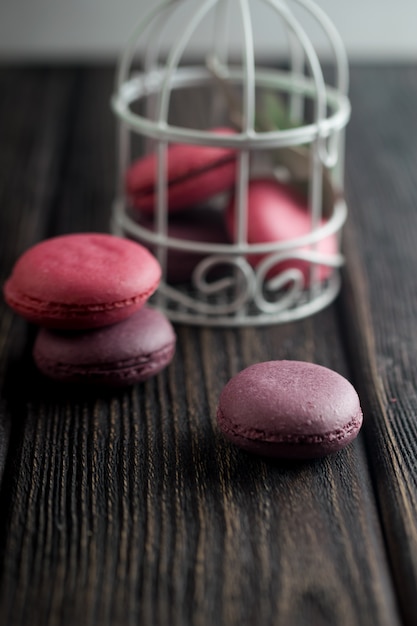 Groep macarons gemaakt van aardbeien, room, chocolade en bosbessen. Rustieke foto.