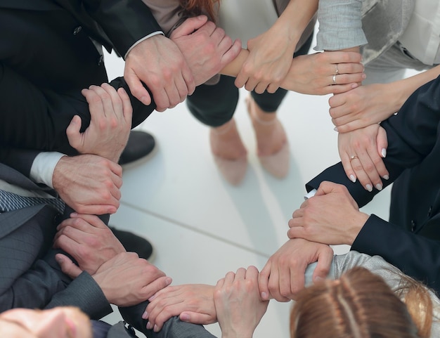 Groep medewerkers die een cirkel vormen uit handenhet concept van teambuilding