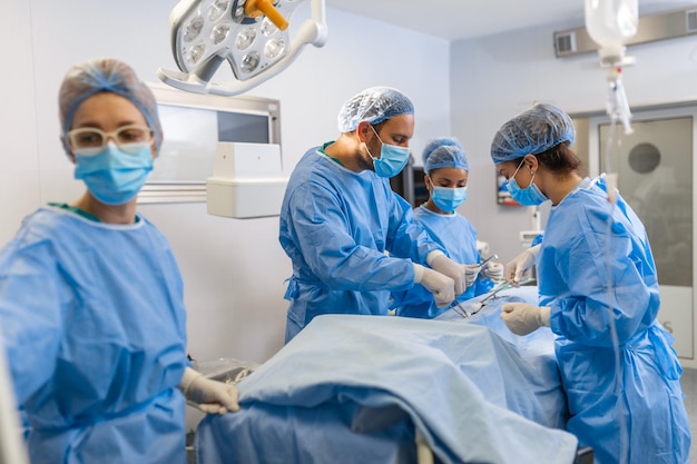 Groep medisch team die dringend een chirurgische ingreep uitvoert en de patiënt helpt in het theater in het ziekenhuis Medisch team dat een chirurgische ingreep uitvoert in een lichte moderne operatiekamer