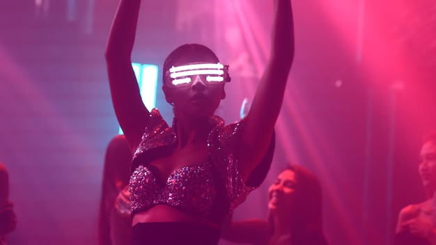 Groep mensen dansen in disco nachtclub op het ritme van muziek van DJ op het podium