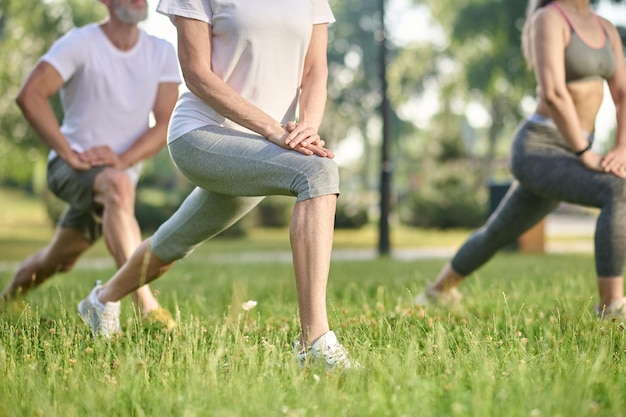 Groep mensen die aan het trainen zijn en samen lunges doen