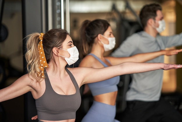 groep mensen die in een sportschool traint en maskers draagt vanwege covid-19