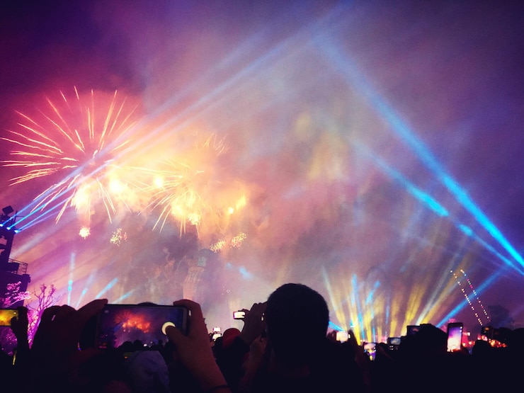 Foto groep mensen die's nachts vuurwerk fotograferen