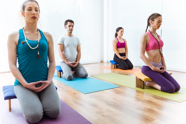 Groep mensen die yoga thuis oefenen. Vajrasana vormen.