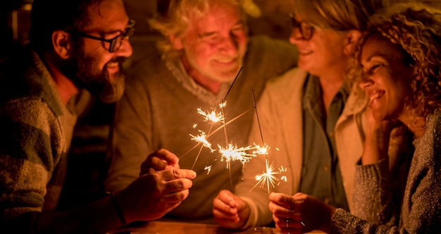 Groep mensen en familie die samen een feestje of nieuwjaar vieren op het terras van het huis - vier sterretjes in het midden samen