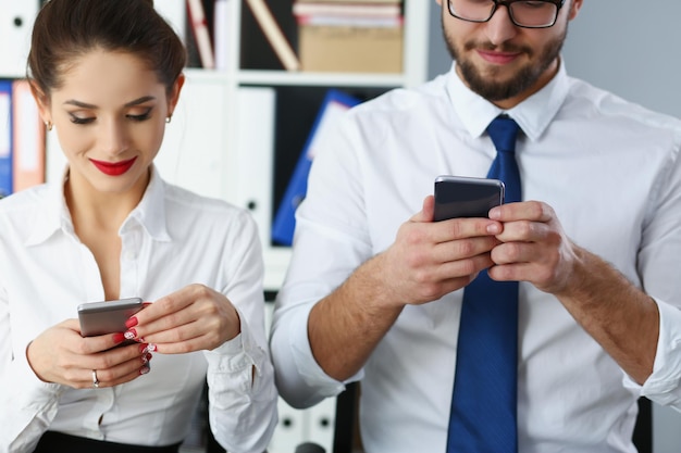 Groep mensen houden apparaten vast en kijken naar het telefoonscherm op kantoor