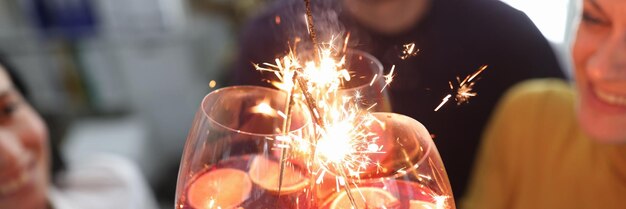 Groep mensen houdt een bril met cocktail met alcohol en sterretjes vast