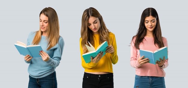 Groep mensen met kleurrijke kleding die een boek houden en van het lezen op kleurrijke achtergrond genieten