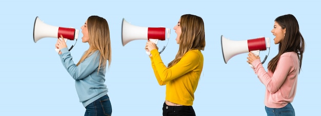 Groep mensen met kleurrijke kleding schreeuwen door een megafoon