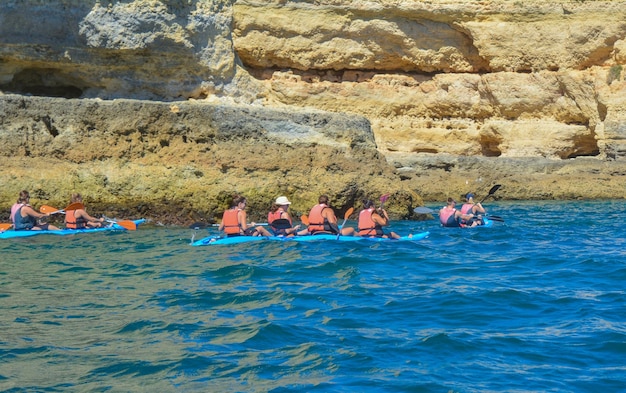 Groep mensen op kanoën in de oceaan met bergen Kajaks