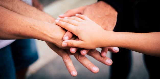 Groep mensen van verschillende leeftijden die elkaar aanraken en vasthouden als een teamconcept - familie en vrienden in de buitenlucht die de handen in elkaar slaan