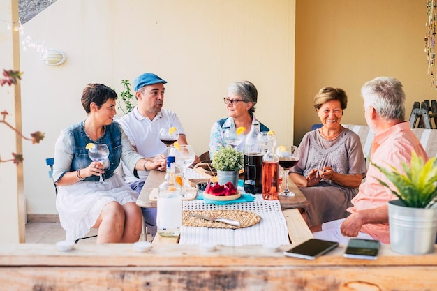 Groep mensen van verschillende leeftijden genieten samen van lunchtijd in vriendschap Familie met volwassenen en senioren vieren traditionele gebeurtenis thuis buiten Gelukkige vrienden voor mannen en vrouwen