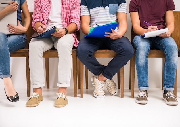 Groep mensen zitten op stoelen wachten op interviews