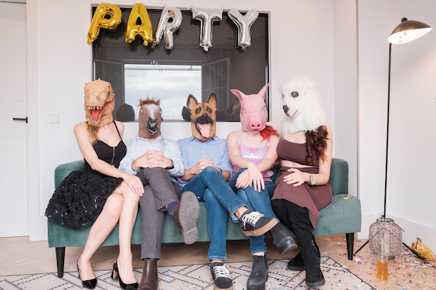 Groep mensen zittend op de bank met dierenmaskers Concept levensstijl dieren wild