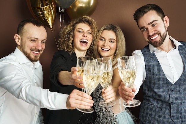 Groep mooie goed geklede feestgangers die vakantie of evenement vieren en mousserende wijn drinken