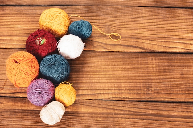 Groep multi-coloured wollen clews op een houten achtergrond.