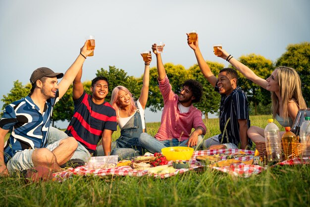 Foto groep multi-etnische tieners die tijd doorbrengen buiten op een picknick in het park