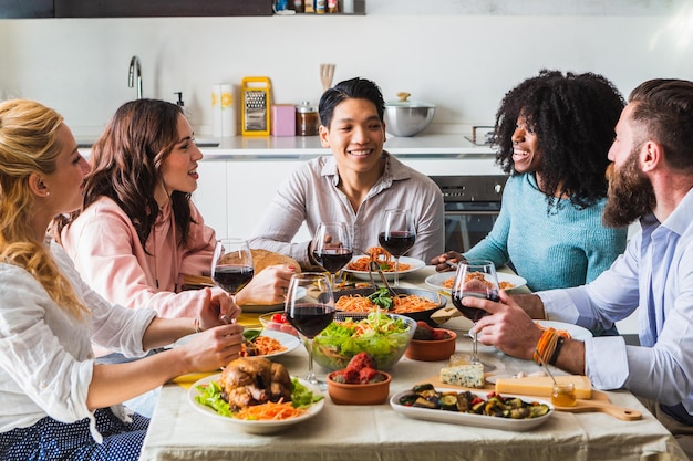 Groep multi-etnische vrienden aan tafel tijdens de lunch