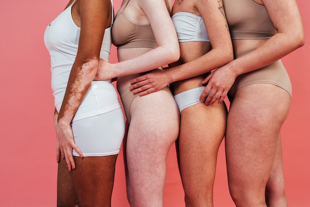 groep multi-etnische vrouwen met verschillende soorten huid die samen in de studio poseren posing
