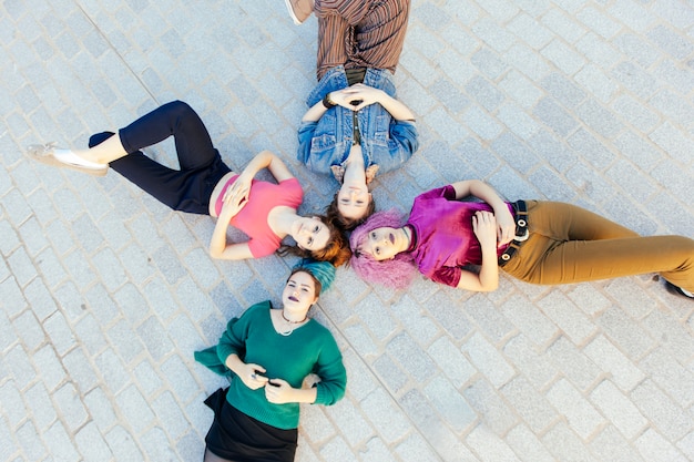 Groep op de vloer liggen en diversiteits jonge vrouwen die omhoog kijken