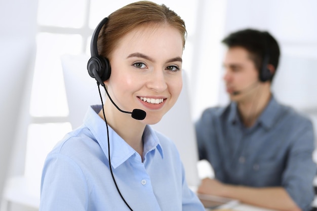 Groep operators aan het werk Callcenter Focus op mooie vrouwelijke receptioniste in headset