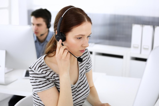 Groep operators op het werk Callcenter Focus op vrouwelijke receptioniste in headset bij klantenservice