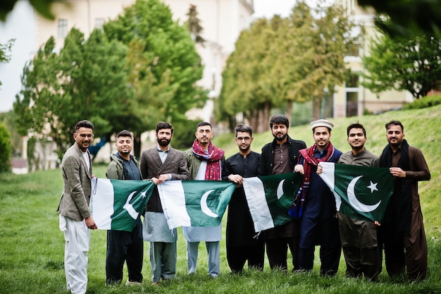 Foto groep pakistaanse man die traditionele kleding salwar kameez of kurta draagt met pakistaanse vlaggen.