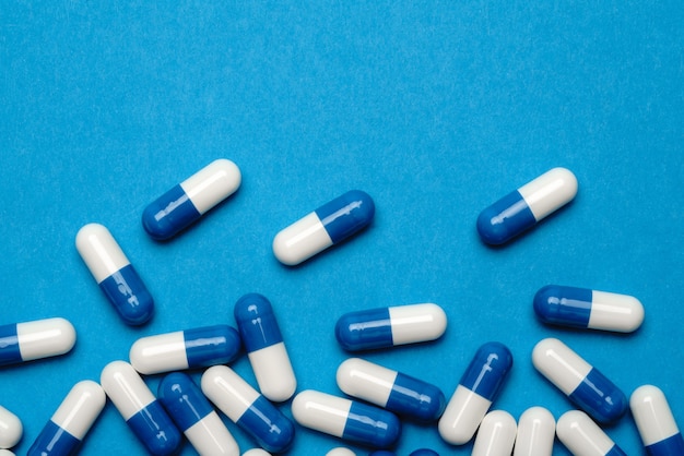 groep pillen of capsules op blauwe achtergrond