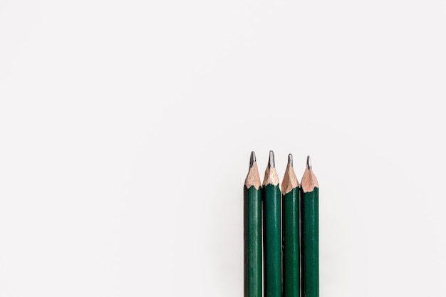 Groep potloden op een witte achtergrond met ruimte voor tekst.