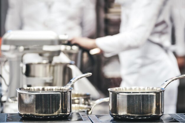 Groep professionele chef-koks werken in een restaurant of hotel en bereiden een maaltijd in een gereduceerde toon