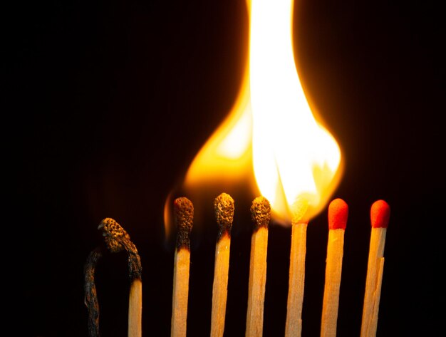 Foto groep rode luciferbranden geïsoleerd op zwarte achtergrond rij branden in kettingreactie