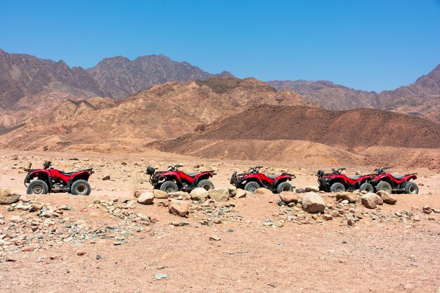 Groep rode quads op de achtergrond van stenen in de woestijn in Egypte