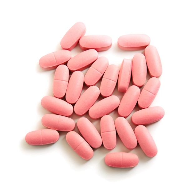 Groep roze medische pillen die op witte achtergrond wordt geïsoleerd