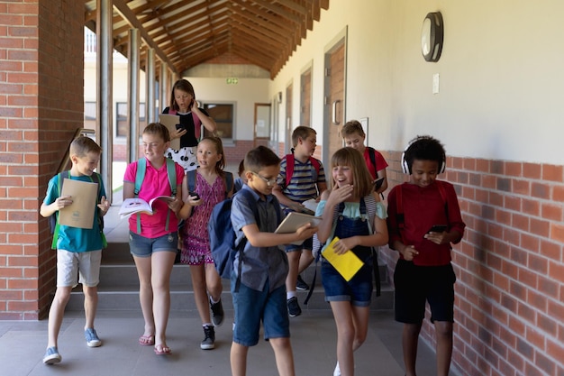 Foto groep scholieren die in een buitengang op de basisschool lopen