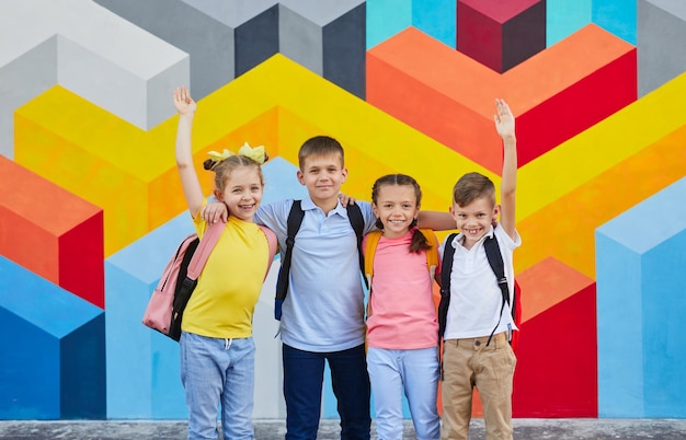 Groep schoolkinderen tegen kleurrijke muur