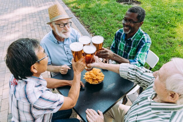 Groep senior vrienden die een biertje drinken in het park. Leefstijlconcepten over anciënniteit en derde leeftijd