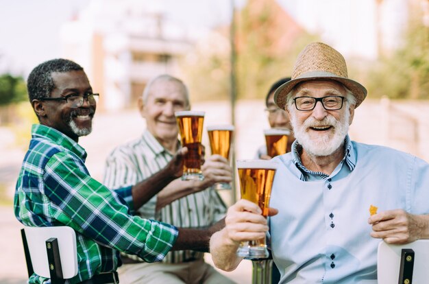 Groep senior vrienden die een biertje drinken in het park. Leefstijlconcepten over anciënniteit en derde leeftijd