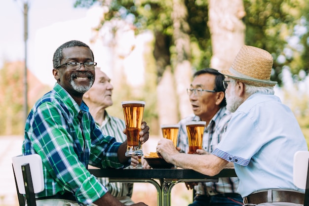 Groep senior vrienden die een biertje drinken in het park. Leefstijlconcepten over anciënniteit en derde leeftijd