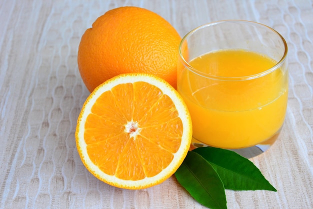 Foto groep sinaasappelen met glas sinaasappelsap geïsoleerd close-up