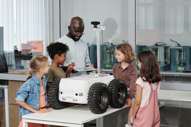 Groep slimme interculturele leerlingen en hun leraar robotica met behulp van tablet