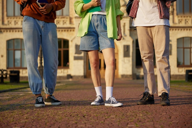 Groep slimme studenten die buiten op de campus staan. Jeugdgemeenschap van middelbare scholen en universiteiten. Bijgesneden opname