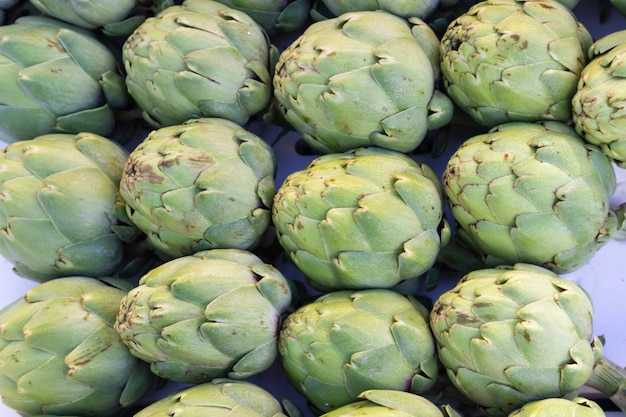 Groep smakelijke natuurlijke artisjokken op straatmarkt