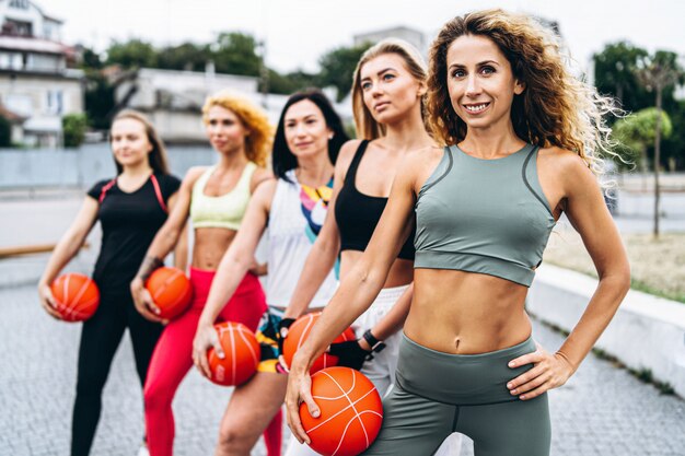 groep sportieve vrouwen die oefeningen met oranje ballen uitvoeren